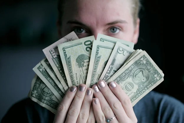 Woman holding a handful of cash