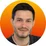 Smiling person with orange background.