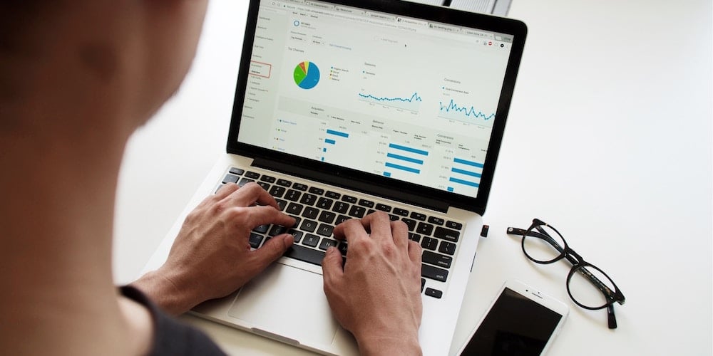 Man looking at analytics on laptop