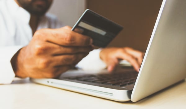 Man with laptop and credit card out to make purchase