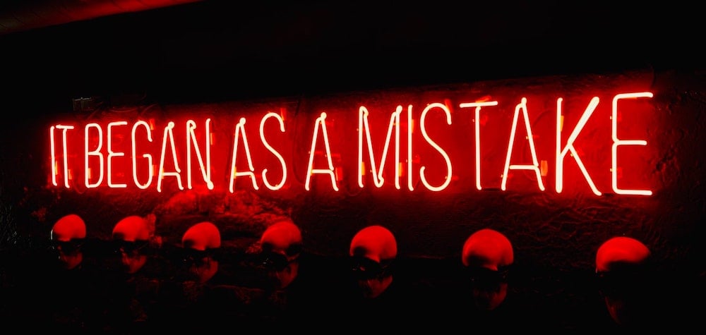Neon sign of "It began as a mistake"